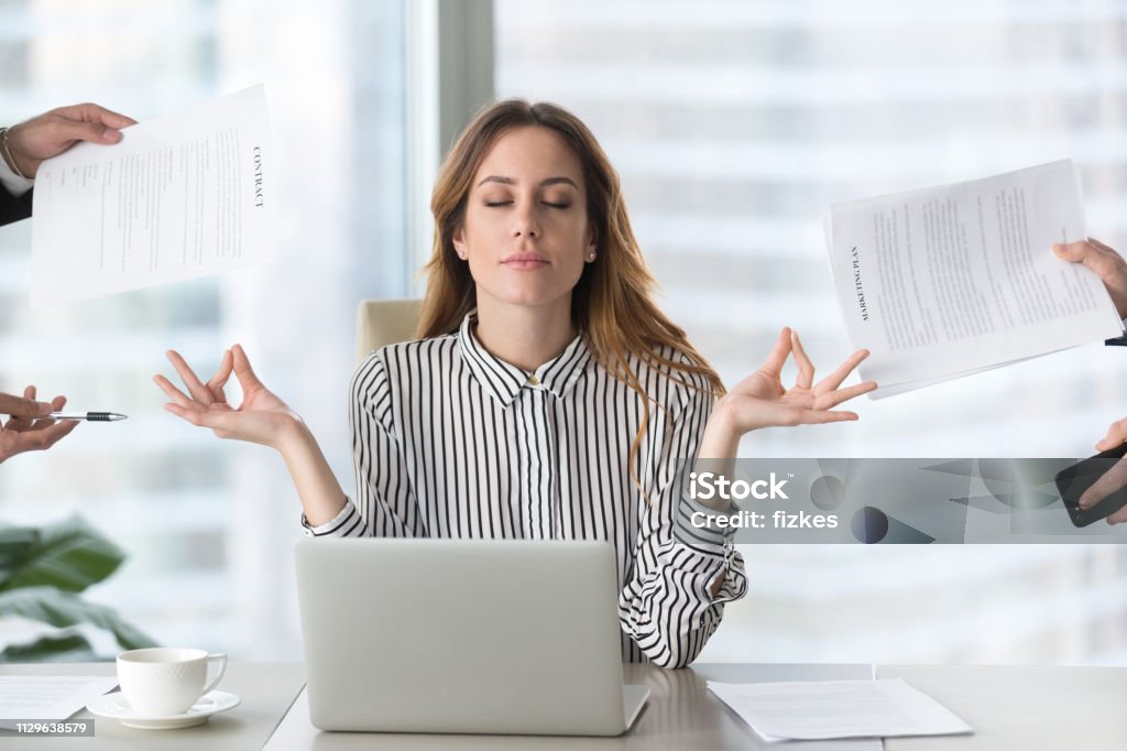 Femme respirant profondément au bureau pour gérer son stress professionnel