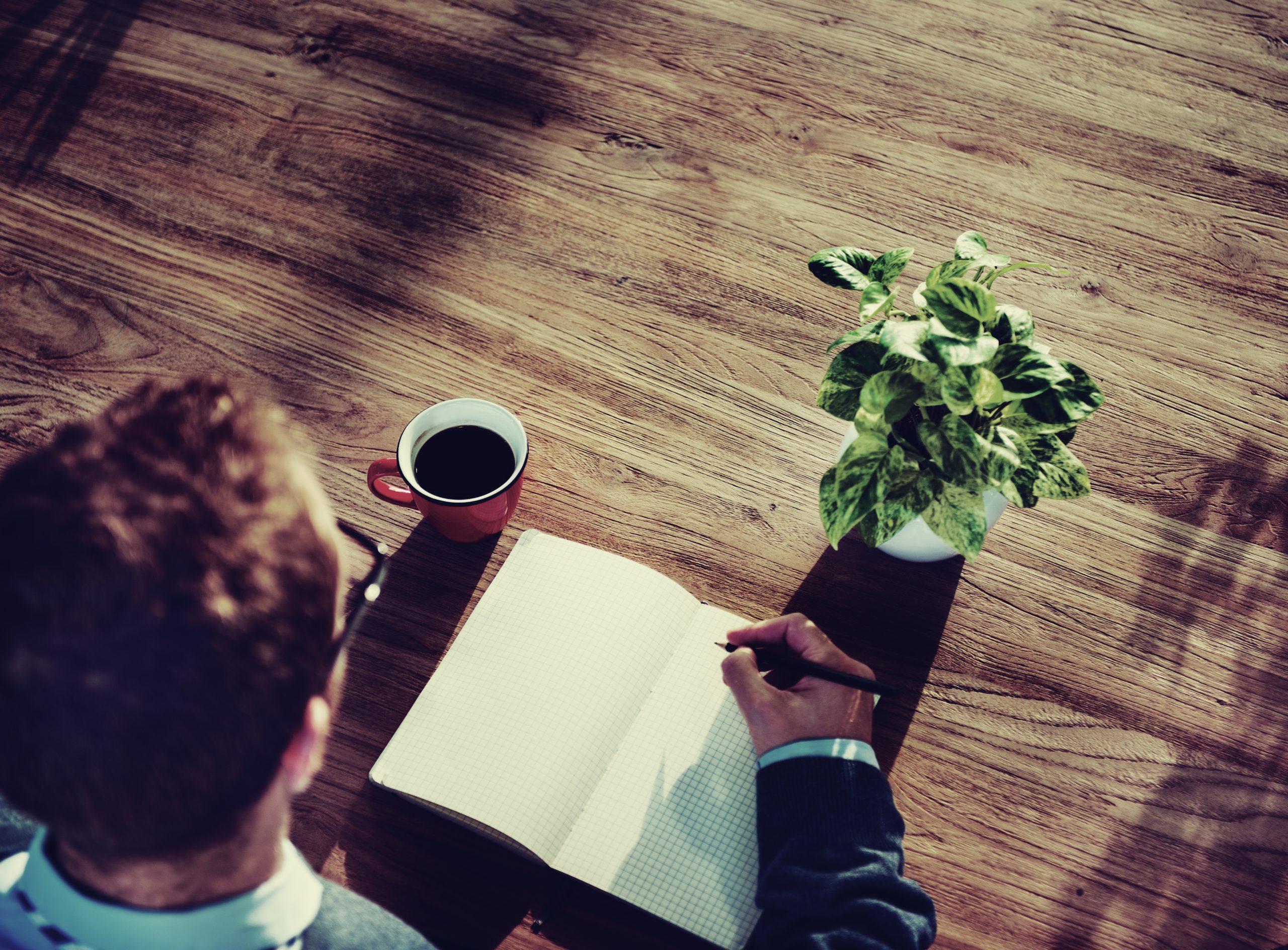 Carnet de notes et tasse de café représentant une pause bien-être et planification personnelle